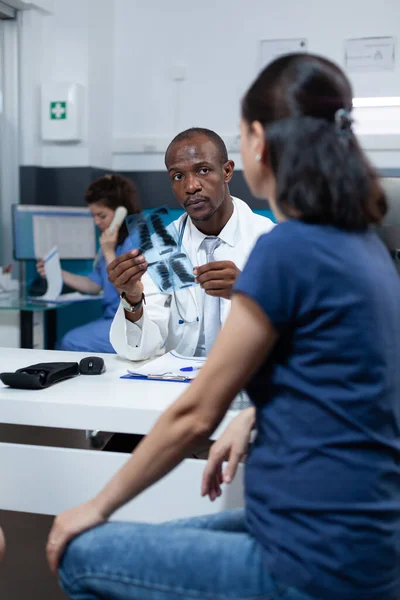 Afrikansk amerikansk barnläkare diktera medicinsk behandling med patient — Stockfoto