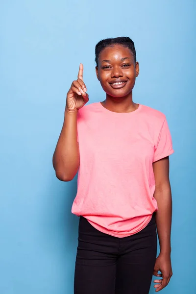 Portrait of smiling african americanteenager showing and lifting finger in sign — Stock Photo, Image