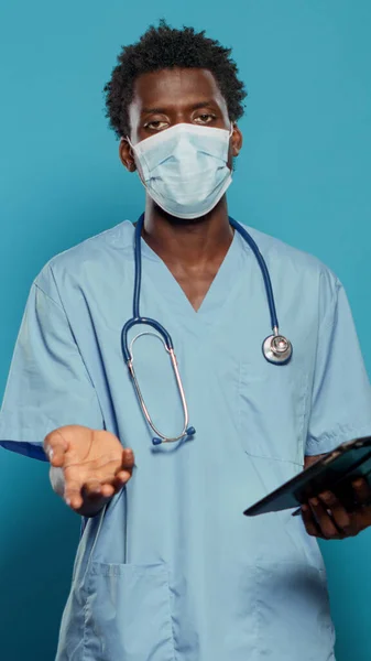 Verpleegster met gezichtsmasker verklaart de coronavirus epidemie. — Stockfoto