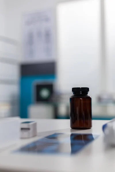 Gros plan sur la bouteille de pilules et radiographie sur le bureau — Photo