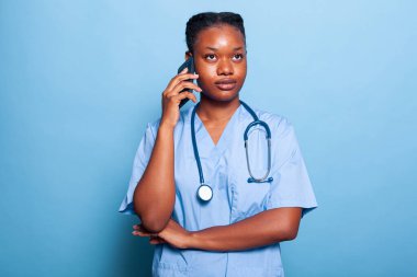 Afrika kökenli Amerikalı pratisyen hemşire telefonda hastalık uzmanlığını tartışıyor.