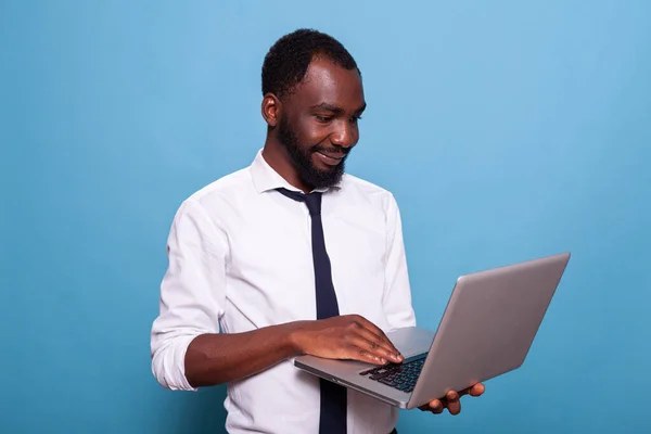 Portrait of relaxed businessman holding laptop looking at screen — Stock Photo, Image