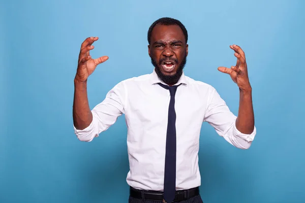 Egy dühös afro-amerikai üzletember arcképe, aki sikoltozik és felemeli a kezét. — Stock Fotó