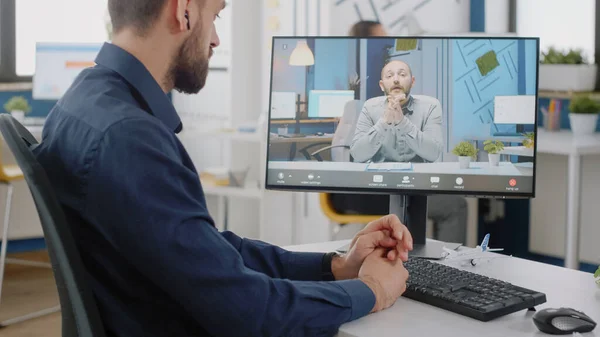 Przedsiębiorca korzystający z połączenia wideo na komputerze do dyskusji z menedżerem — Zdjęcie stockowe