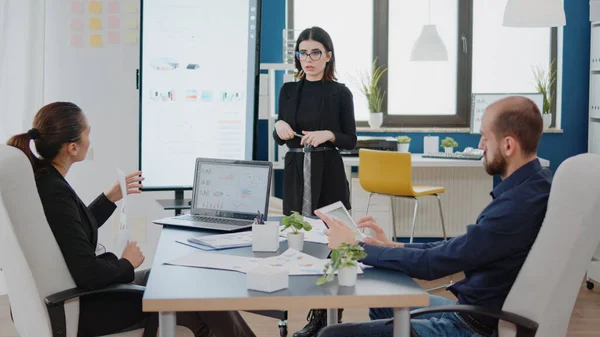 Chers collègues qui regardent la présentation à la télévision avec des tableaux de données — Photo