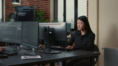 Portrait of asian programer focused on writing code sitting at desk