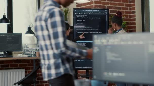 Software engineer holding digital tablet analyzing code on wall screen tv explaining errors to colleague programer — Stok video