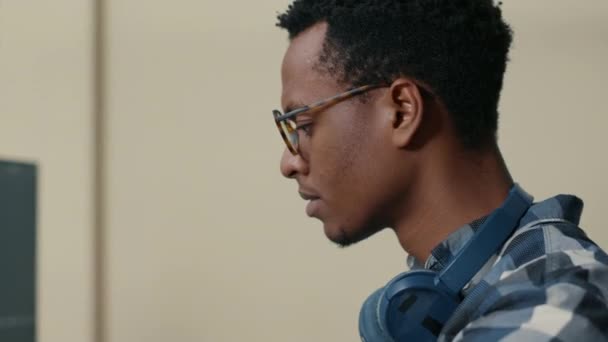 Portrait of african american database developer with glasses working focused looking at computer — Stockvideo