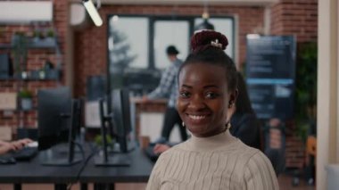 Smiling african american programer sitting down holding laptop