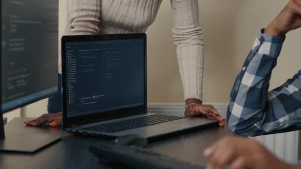 Closeup of laptop running algorithm parsing code on desk in front of programmers doing team work — Vídeo de stock