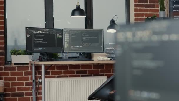 Desk with multiple computer monitors displaying parsing code and programming language compiling — 图库视频影像