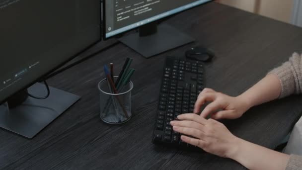 Closeup of caucasian programer hands typing code on keyboard in front of computer screens — Video Stock