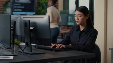 Asian software developer focused on writing code encounters unexpected compiling error sitting at desk