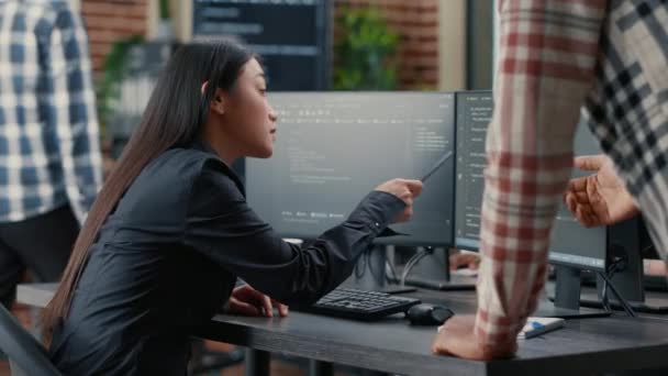 Database developer pointing pencil at computer screen with software compiling code explaining source algorithm to coworker — Αρχείο Βίντεο