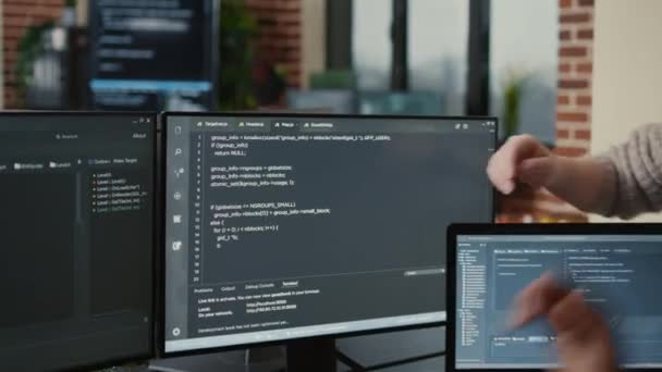 Software developer looking at running code on multiple screens takes off glasses and doing high five hand gesture — стоковое видео