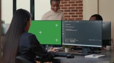 Software developer writing algorithm in front of computer with green screen chroma key mockup