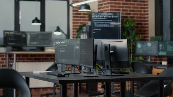 Computer screens running programming code in empty software developing agency office — Stok video