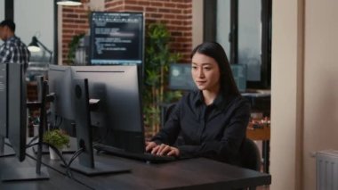 Smiling software developer typing machine learning app code on computer keyboard