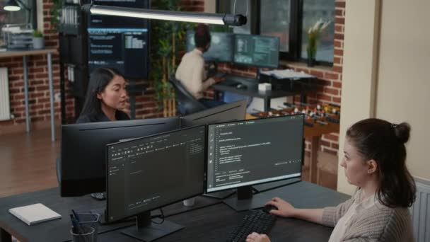 Junior developer sitting down on desk showing laptop with source code to senior dev — Video