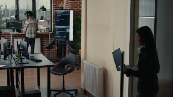 Software developer holding laptop with source code algorithm entering programmers agency office — Video