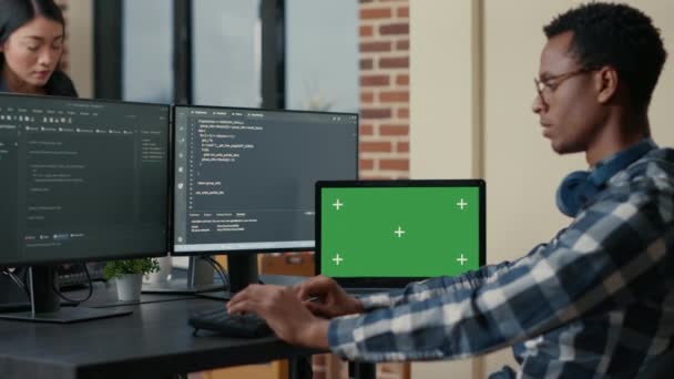 Software developer writing code using computer keyboard and laptop with green screen chroma key mockup — Αρχείο Βίντεο