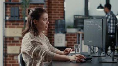 Bilgisayar klavyesine kaynak kod yazan programcı başını çeviriyor ve gülümsüyor