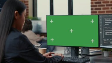 Asyalı programcının kod yazarken önünde yeşil ekran krom anahtar modeli olan bilgisayar ekranına odaklan
