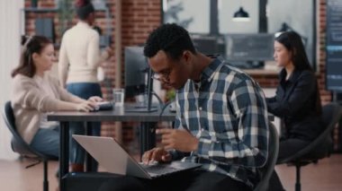 Yapay zeka uygulama geliştiricisinin portresi dizüstü bilgisayarda oturuyor, bardakları tamir ediyor ve gülümsüyor.