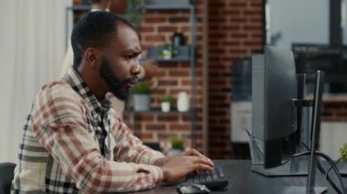 Portrait of programer typing programming code on computer keyboard turning head and smiling