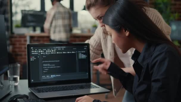 Equipo de desarrolladores de software hablando de código fuente que se ejecuta en la pantalla del ordenador portátil — Vídeo de stock