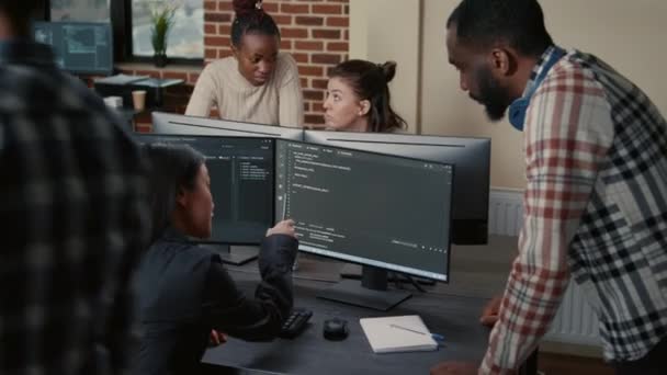 Mixed programmers team working on group project on multiple screens showing running code — Vídeo de Stock