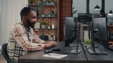 Bilgisayar klavyesinde programlama kodu yazan yazılım geliştirici başını çeviriyor ve gülümsüyor