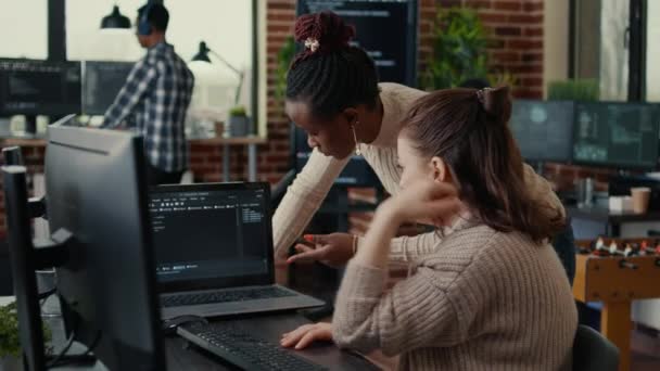 Two software coders analyzing source code looking for errors running on laptop screen — Αρχείο Βίντεο