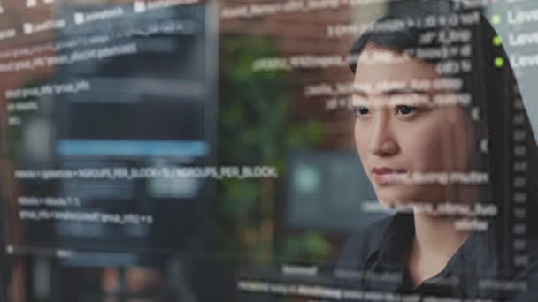 Portrait of focused asian software developer through vfx of floating programming code — Wideo stockowe