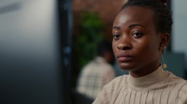 African american software programer working focused looking at computer screen and smiling while typing