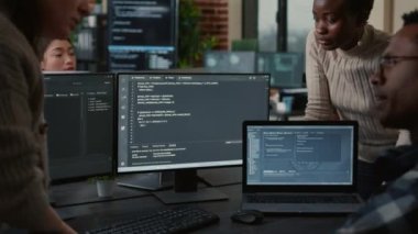 Software developers discussing about programming while the rest of the team joins the discussion