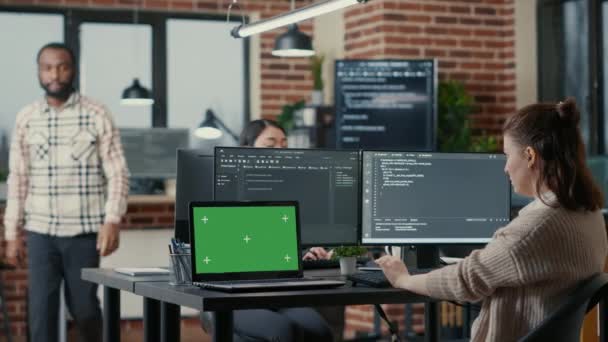 Програміст працює за столом з декількома екранами комп'ютера і ноутбуком з зеленим екраном макет ключа хрому — стокове відео
