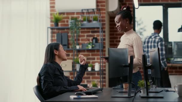 Προγραμματιστής όρθιος κρατώντας ψηφιακό δισκίο μιλώντας με κωδικοποιητή κάθεται στο γραφείο μπροστά από την οθόνη του υπολογιστή — Αρχείο Βίντεο