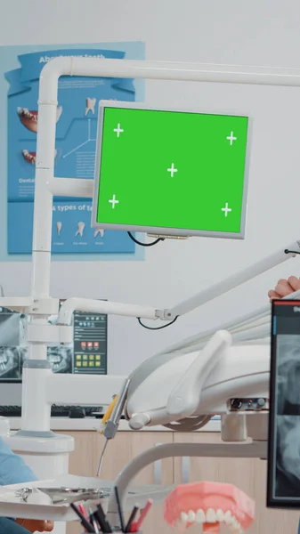 Dentista e assistente che guardano lo schermo verde sul monitor — Foto Stock