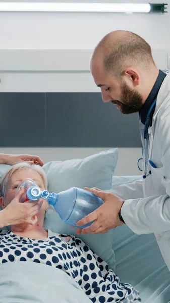 患者の酸素管と酸素濃度計を使用した医師と看護師 — ストック写真