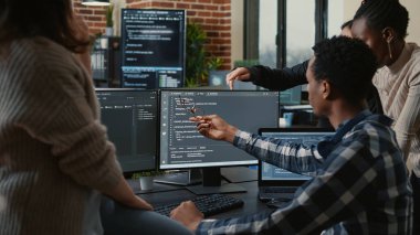 Software developers discussing about source code compiling discovers errors and asks the rest of the team for explanations
