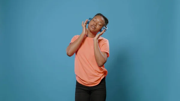 Pozytywna kobieta bawiąca się ze słuchawkami i rytmem — Zdjęcie stockowe