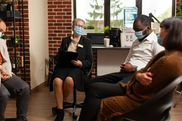 People attending group therapy session with psychologist during covid 19 pandemic — Stock Fotó