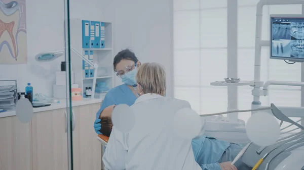 Sjuksköterska och stomatolog med borrverktyg för att avlägsna karies — Stockfoto