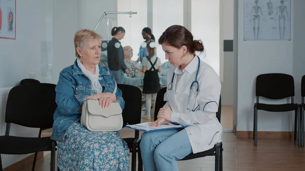 Close up of physician explaining diagnosis results to old woman — 스톡 사진