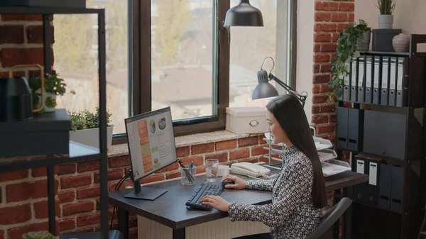 Mujer de negocios que trabaja en los gráficos de datos anuales en la oficina — Foto de Stock