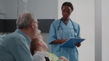 African american nurse talking to elder patient and family