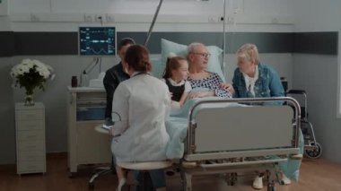 Hastane koğuşundaki kadına röntgen sonuçlarını gösteren doktor.