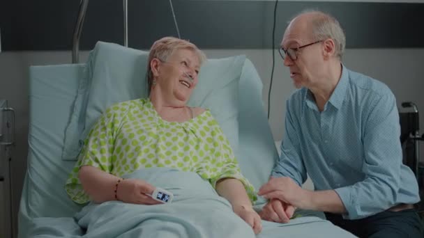 Mother and child visiting sick grandma in hospital ward bed — Vídeos de Stock
