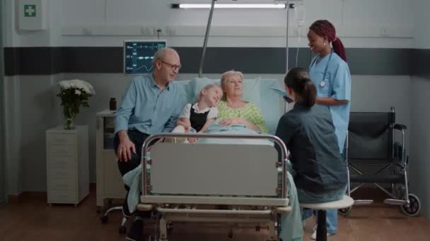 Medische assistent legt diagnose uit aan zieke vrouw en familie — Stockvideo